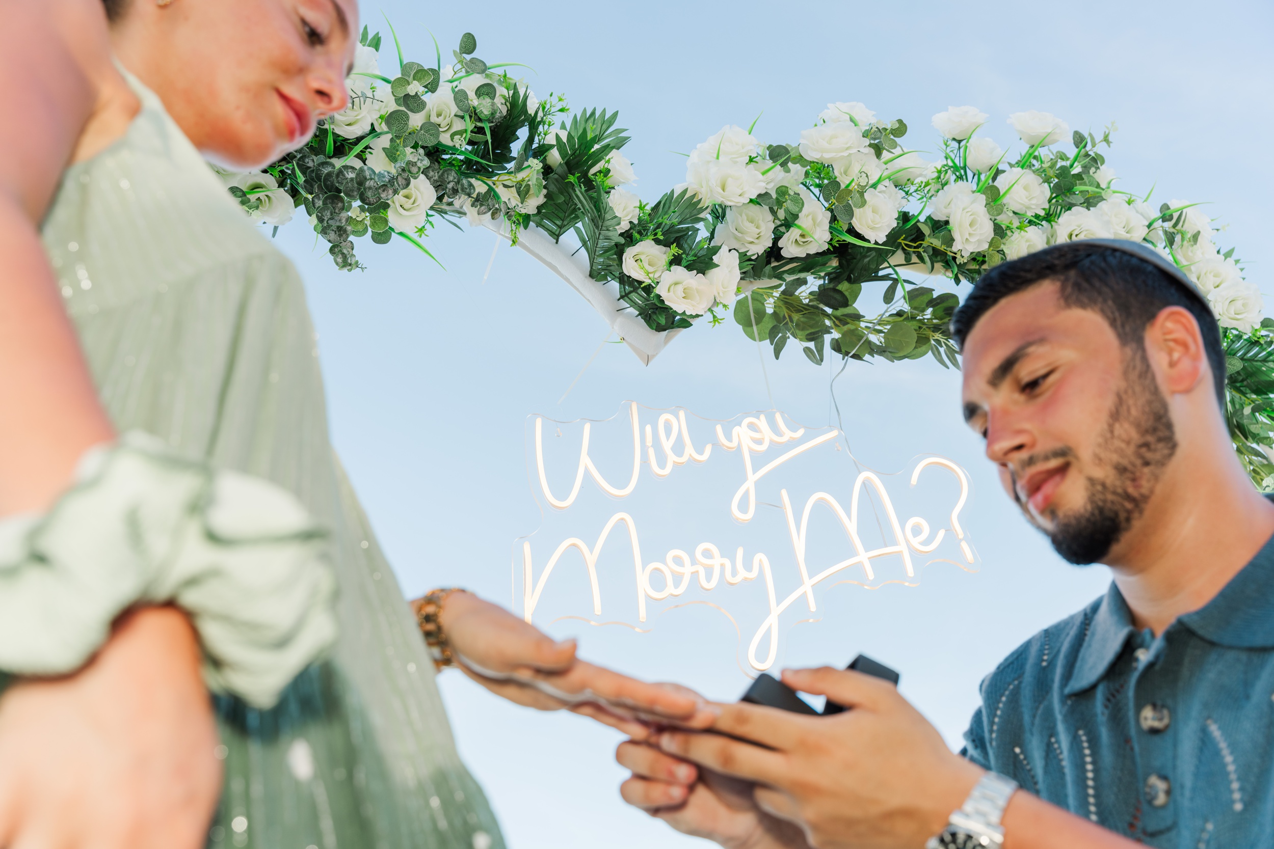 A man puts the ring on the finger of his new fiancee during their proposal Miami