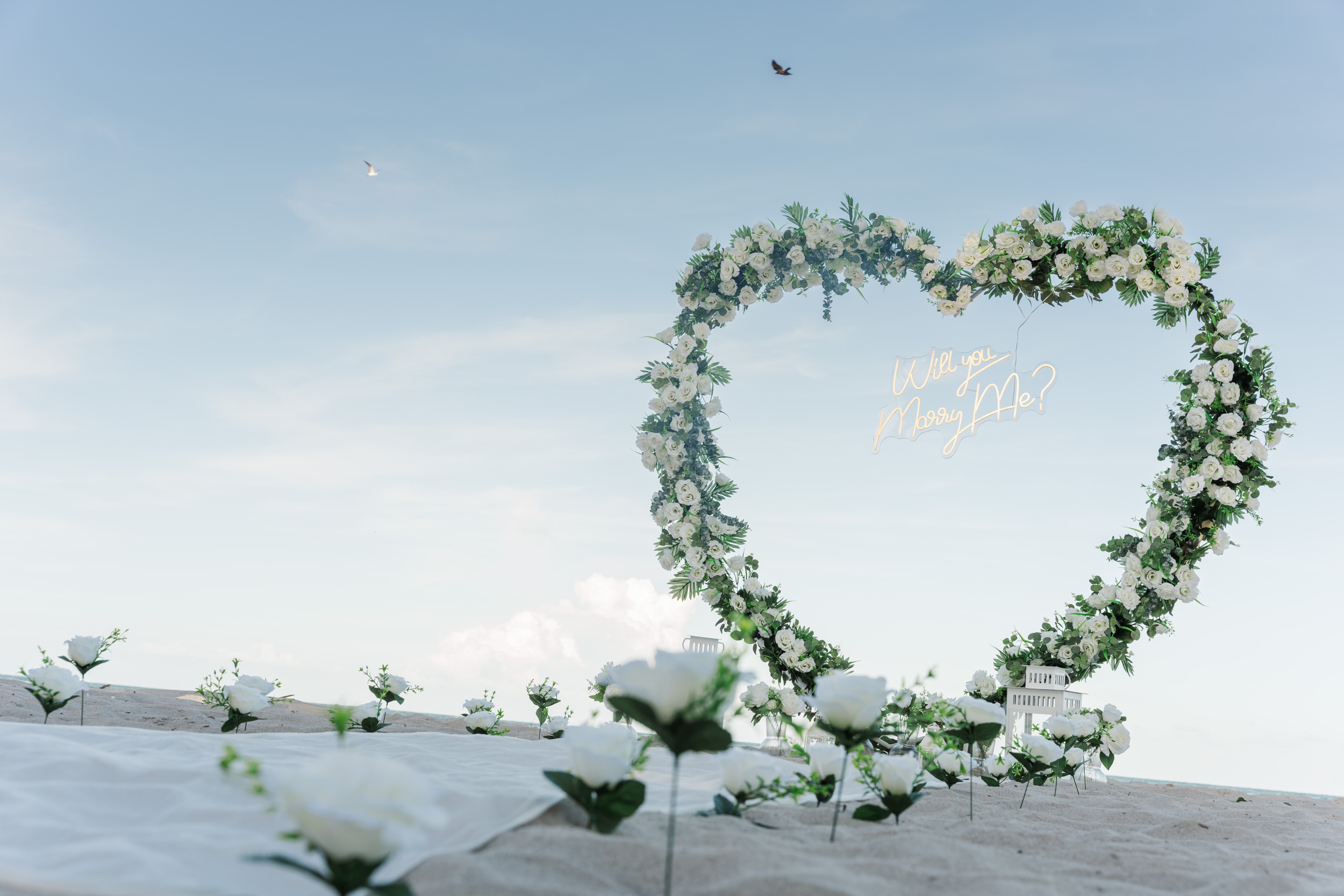 Details of a heart shaped white rose arch on a beach for a proposal Miami