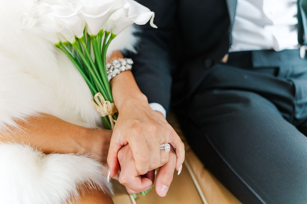 Newlyweds hold hands in the backseat of a car while leaving wedding venues in west Palm Beach