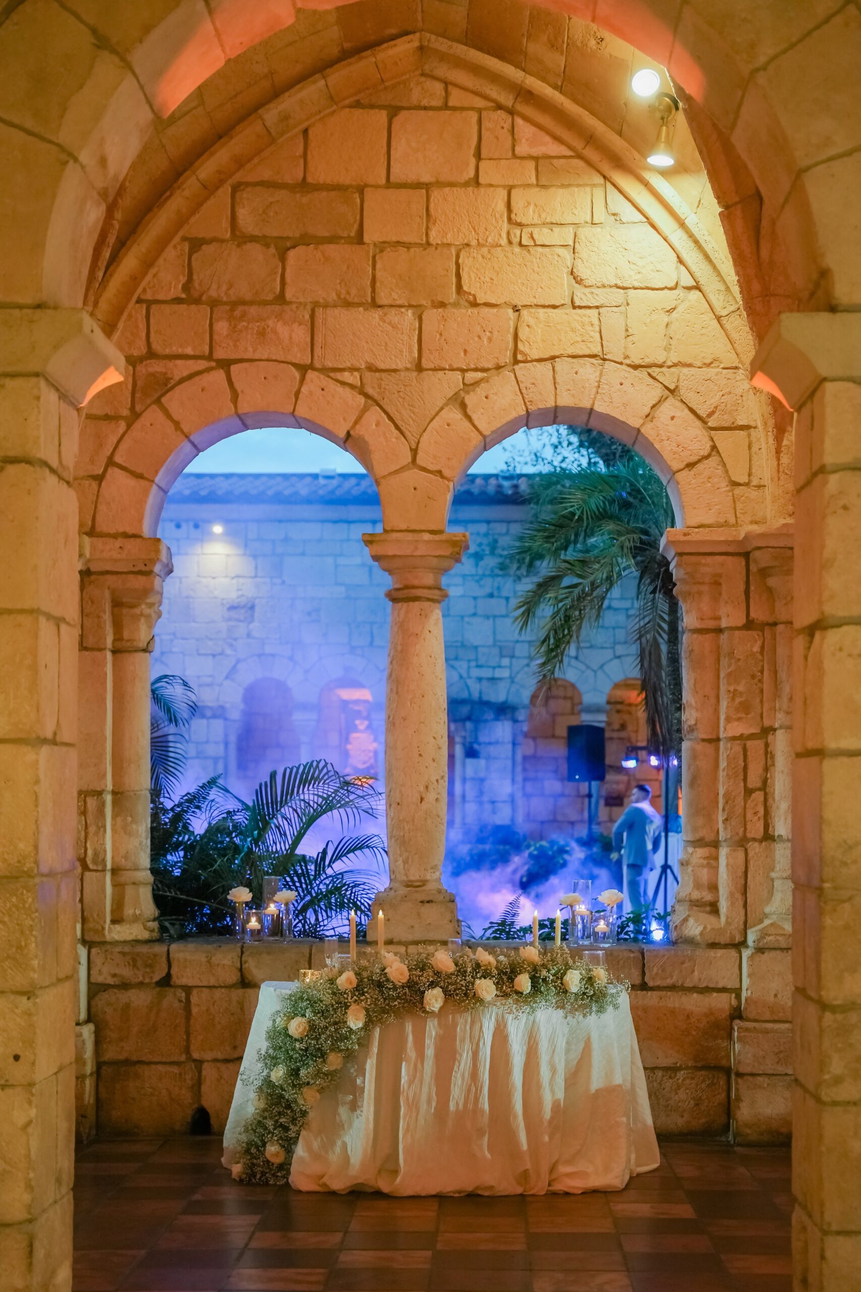 A head table sits in a stone archway at the Ancient Spanish monastery wedding venue