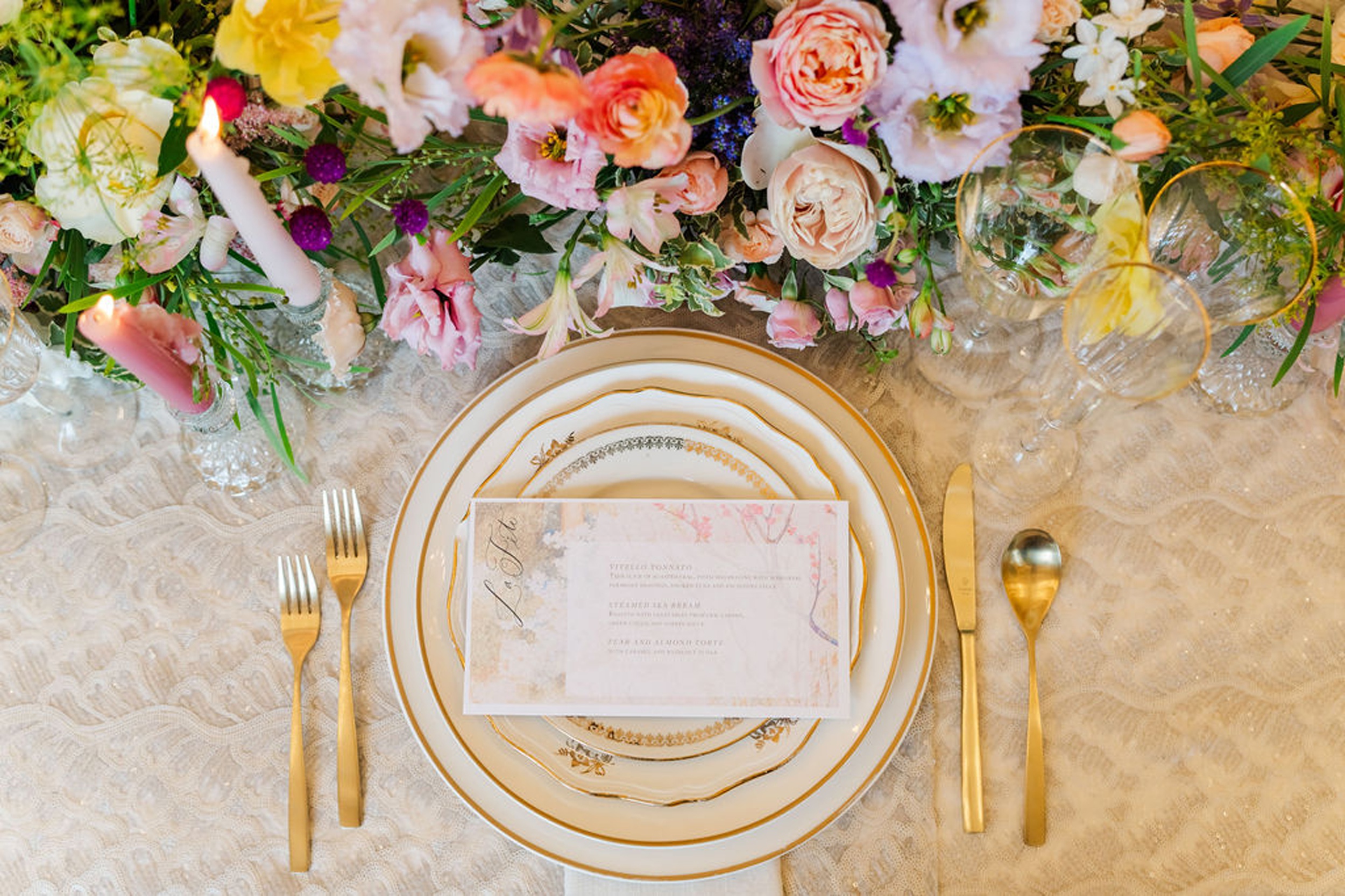 Details of a gold table setting surrounded by colorful flowers at one of the wedding venues in naples florida